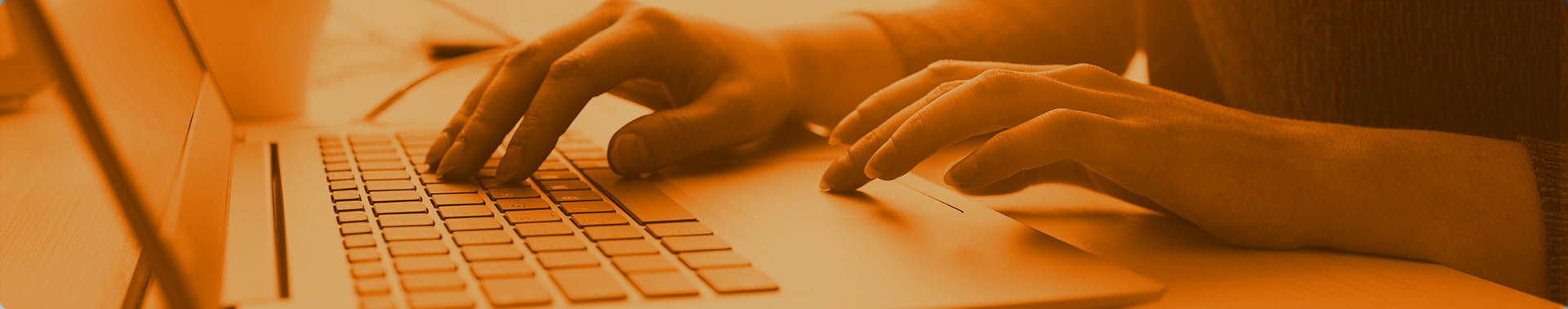 Hands shown typing on a laptop computer